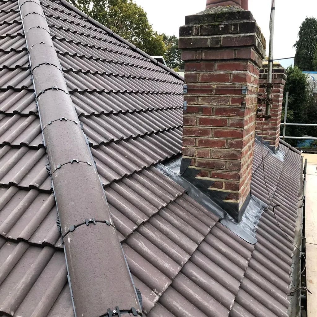 Finished tiled roof with new ridge and lead flashing around the chimney